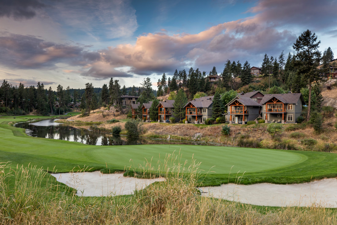 Predator Ridge green and bunkers with lakeside cottages and a sunset sky